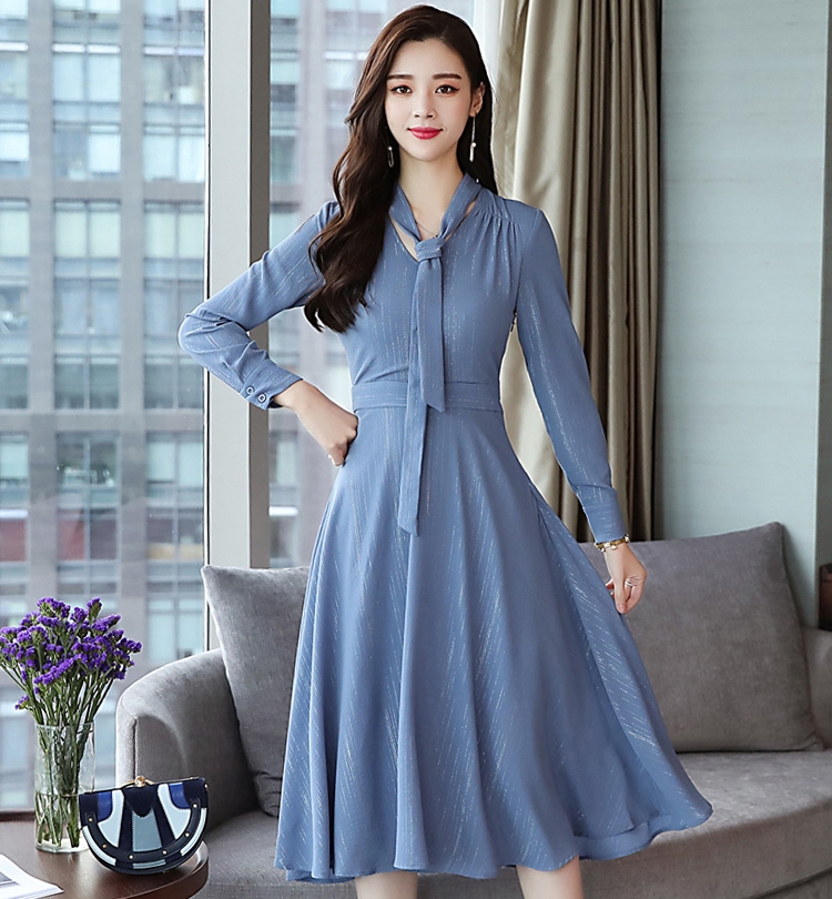 ชุดเดรสสั้นสีเทาอมฟ้า คอวีผูกโบว์ แขนยาว กระโปรงสั้นคลุมเข่าทรงบาน ผ้าชีฟองแต่งกากเพชรเลื่อมเงิน แนวเรียบๆ ดูดีใส่ได้หลายโอกาส