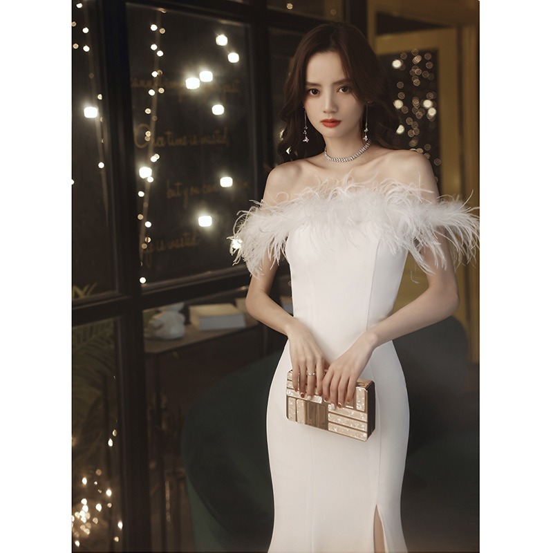 ชุดราตรียาวสีขาวปาดไหล่แต่งขนฟูๆ กระโปรงผ่าหน้าทรงหางปลา เรียบหรูดูแพง สวยหรูดูดี แบบสวยทันสมัย
