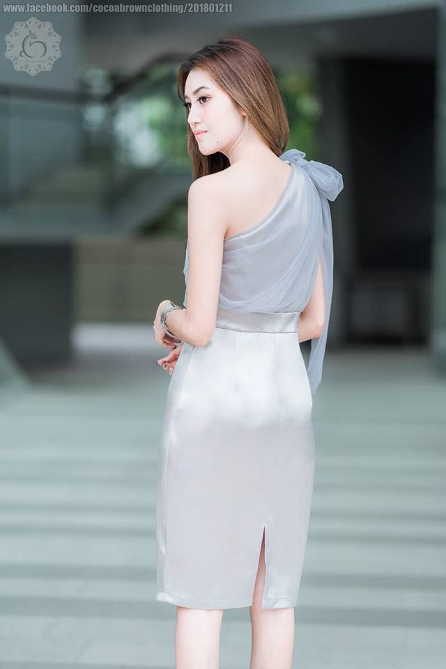 ชุดออกงานราตรีสั้นสีเทา ทรงเข้ารูป ไหล่เฉียงข้าง แต่งด้วยผ้าซีทรูยาวระบายหลังผูกเป็นโบว์ได้หลายแบบ