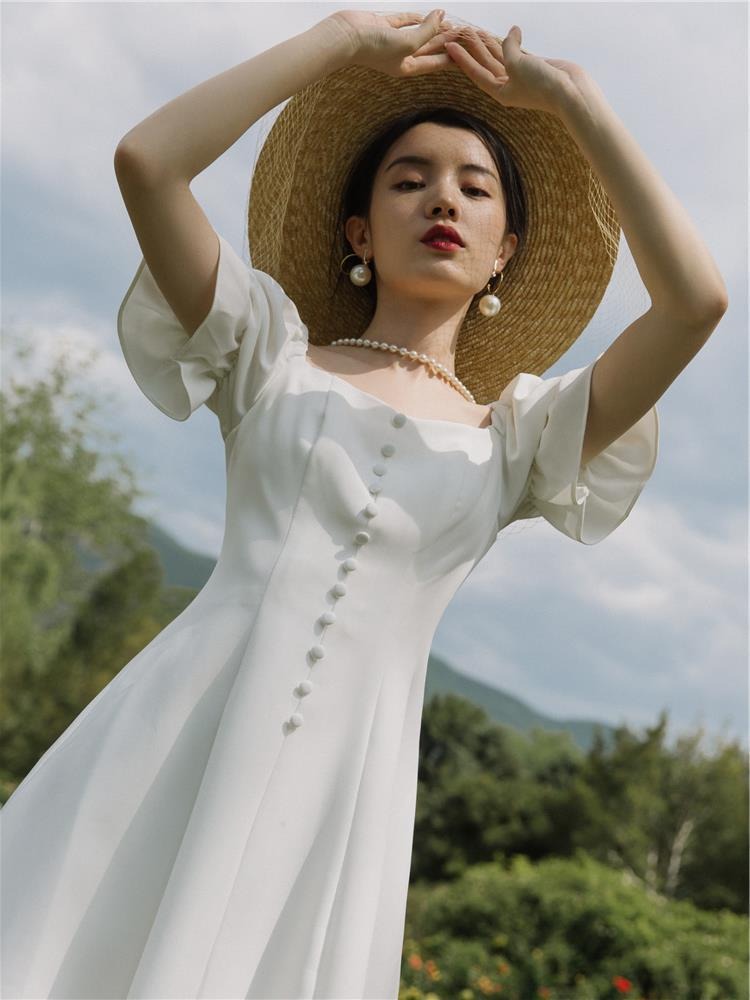 ชุดเดรสออกงานสีขาว แขนตุ๊กตา แต่งกระดุมมุก กระโปรงสั้นทรงบาน เรียบหรู สวยดูดี สไตล์มินิมอล ใส่เป็น ชุดราตรี ชุดออกงาน ชุดไปงานแต่งงาน กลางวัน กลางคืน