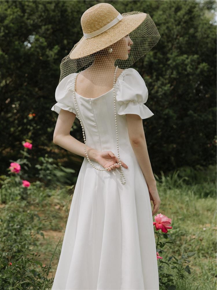 ชุดเดรสออกงานสีขาว แขนตุ๊กตา แต่งกระดุมมุก กระโปรงสั้นทรงบาน เรียบหรู สวยดูดี สไตล์มินิมอล ใส่เป็น ชุดราตรี ชุดออกงาน ชุดไปงานแต่งงาน กลางวัน กลางคืน