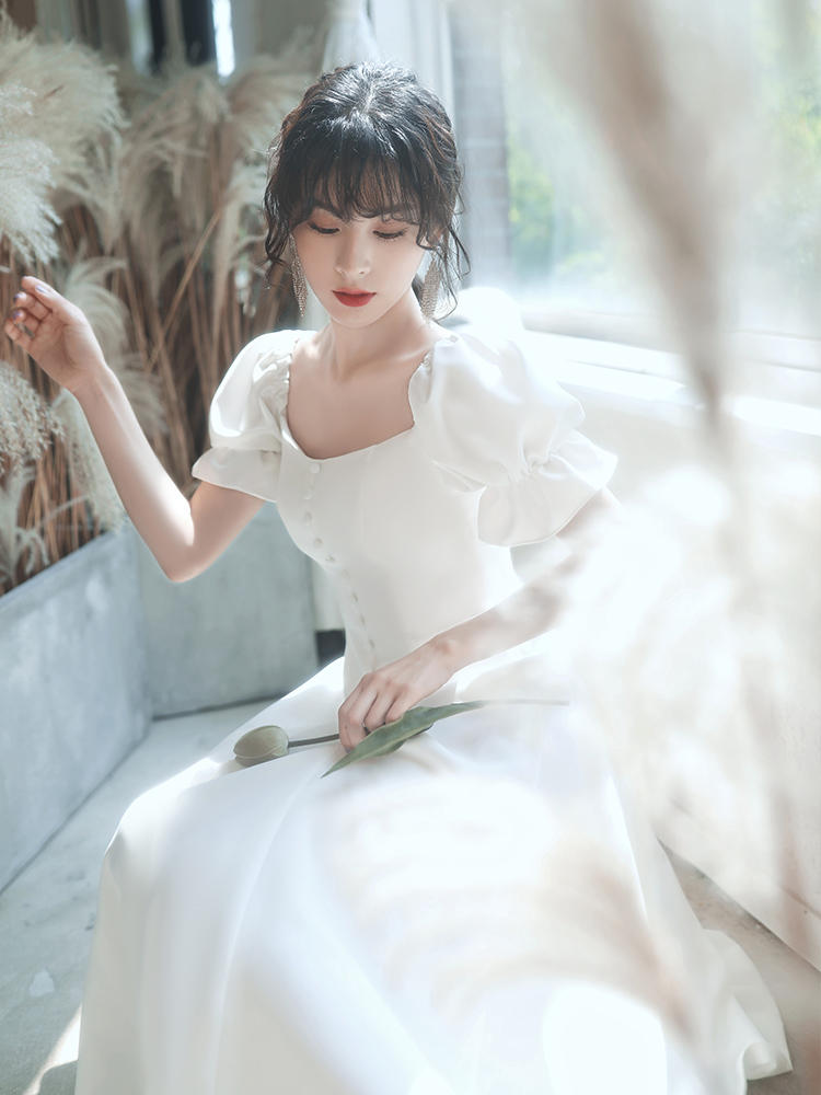 ชุดเดรสออกงานสีขาว แขนตุ๊กตา แต่งกระดุมมุก กระโปรงสั้นทรงบาน เรียบหรู สวยดูดี สไตล์มินิมอล ใส่เป็น ชุดราตรี ชุดออกงาน ชุดไปงานแต่งงาน กลางวัน กลางคืน